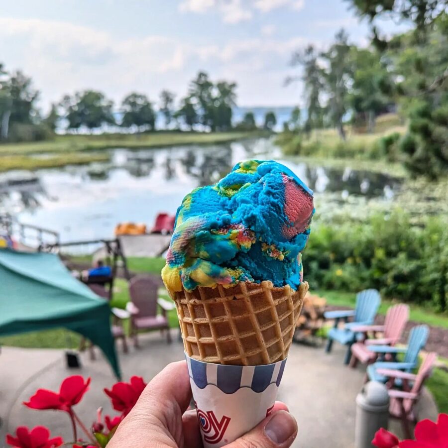 An ice cream cone held in front of a lake view at Boyd Lodge